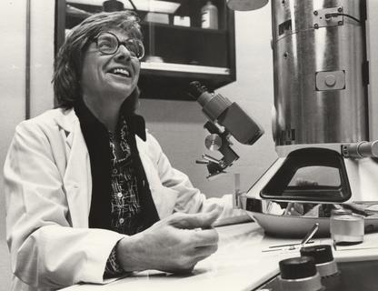 Ruth Bleier sitting at her electron microscope, 1980's